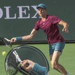 Image of Jannik Sinner hitting a forehand with a closeup of the grip